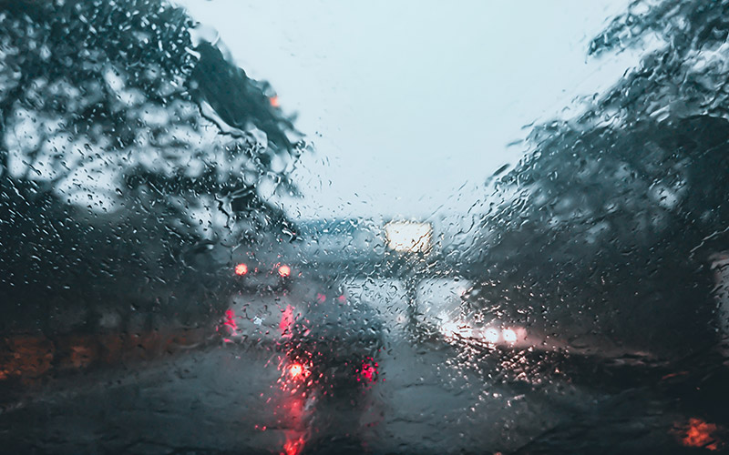 Verschwommenes Foto einer Windschutzscheibe mit starkem Regen, Ansicht aus einem