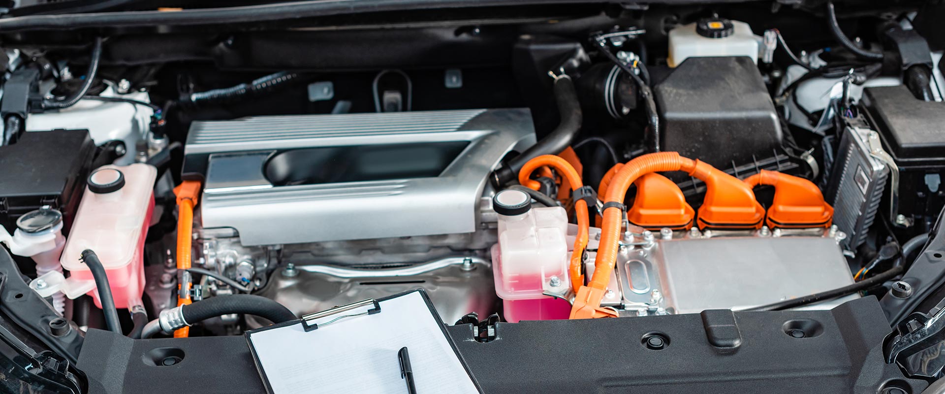 Zwischenablage mit leerem weißem Papier und Stift in der Nähe des Motorraums