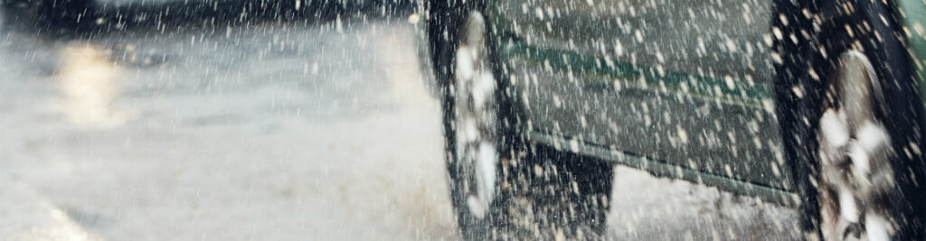 Verkehr an Regentagen in der Stadt. Selektiver Fokus auf den nassen Bürgersteig