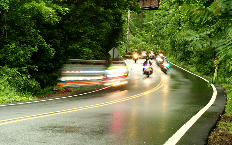 Polizeimotorräder rasen eine Landstraße entlang