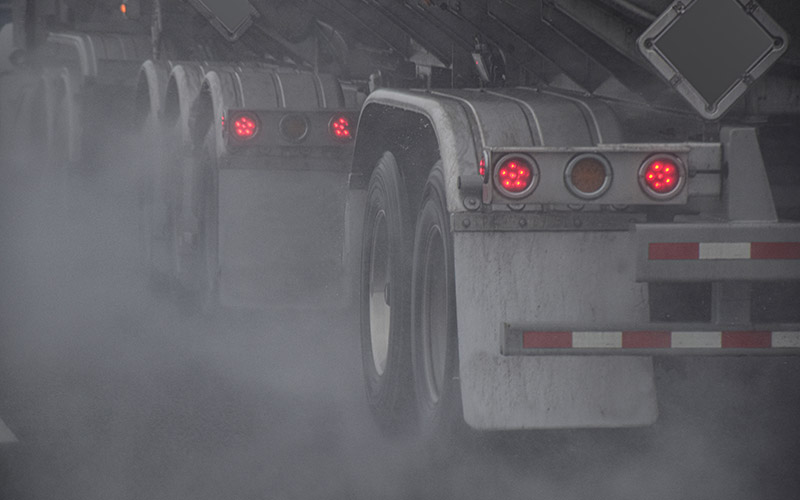Räder eines Traktoranhängers, der bei Regen auf einer Autobahn fährt